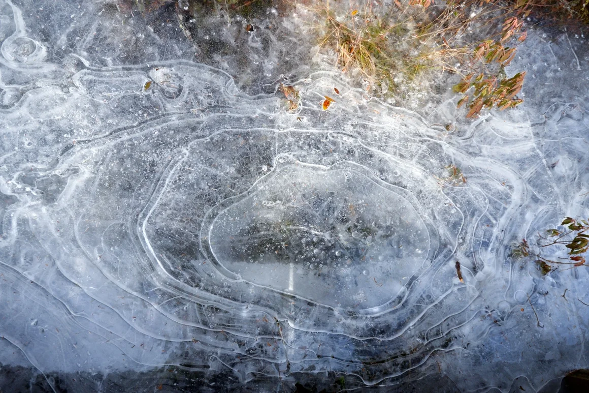 Gefrorene Pfütze mit Lufteinschlüssen