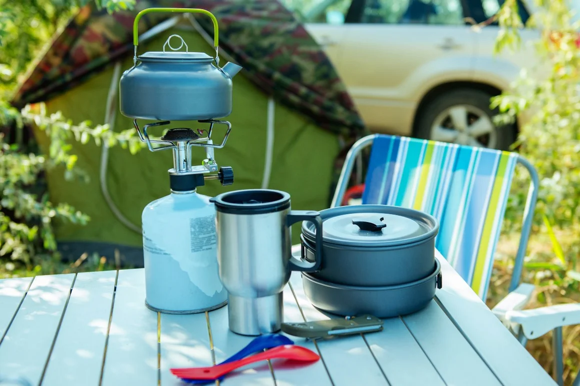 Campingkocher und Geschirr auf Tisch