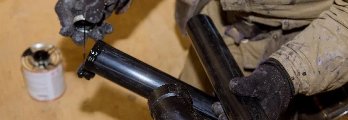 Person verklebt Abflussrohre.