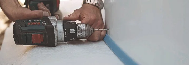 Person bohrt mit Akkuschrauber in Wand