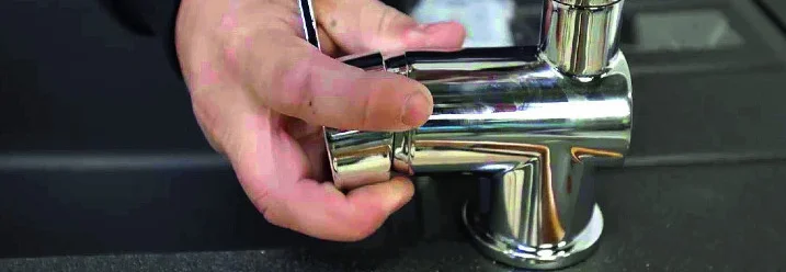 Person montiert einen Wasserhahn.