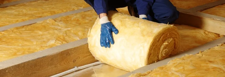 Person dämmt einen Dachboden.