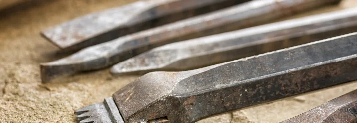 Verschiedene Meißel auf Sand.