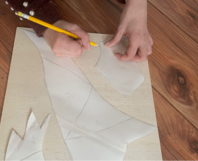 Hände zeichnen mit Bleistift Schnittmuster auf Holzbrett