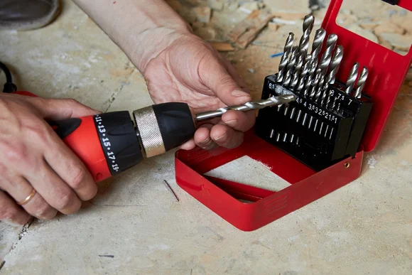 Person setzt Bohrer in Akkuschrauber ein