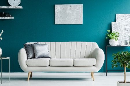 Helles Sofa vor blauer Wand