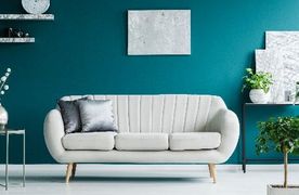 Helles Sofa vor blauer Wand