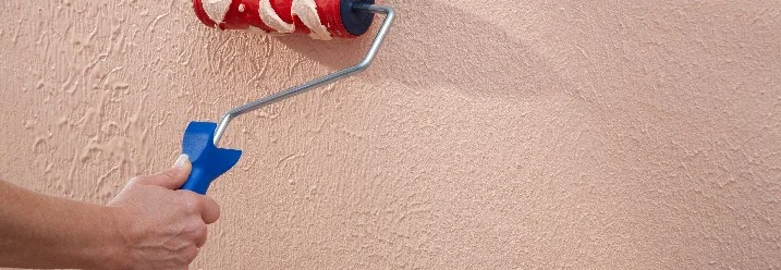 Hand trägt Strukturrolle an Wand