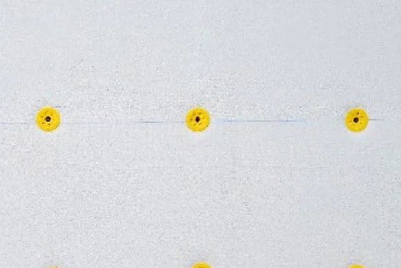 Drei gelbe Dämmstoffdübel in einer weißen Wand