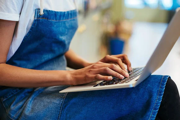 Person tippt auf Laptop