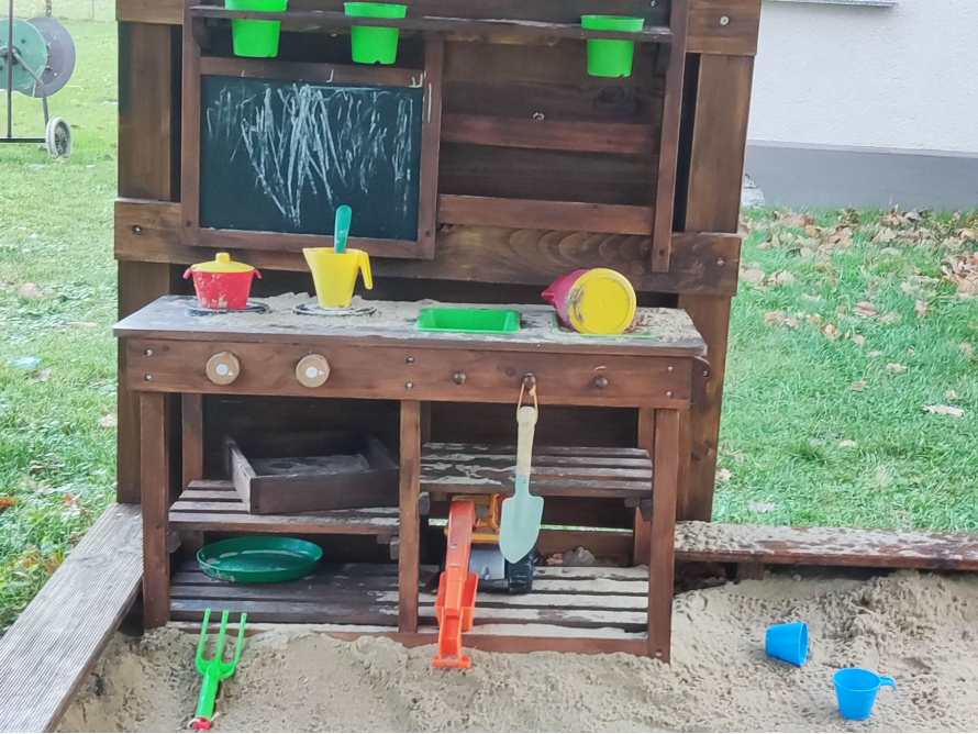 Spielküche aus Holz im Sandkasten