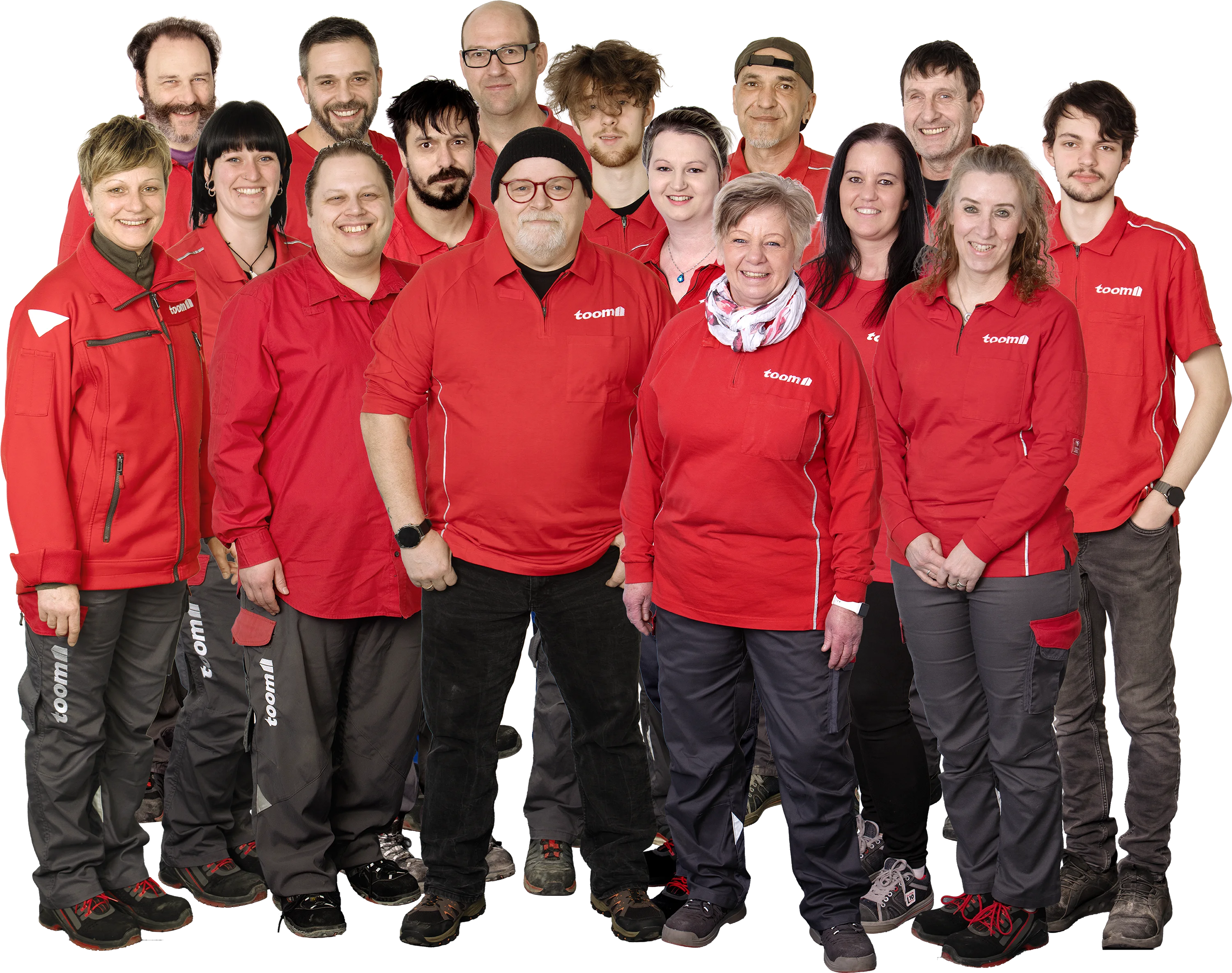 Gruppenporträt von Mitarbeitenden in roter Arbeitskleidung vor schwarzem Hintergrund.