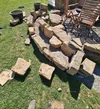 Bau einer geschwungenen Trockenmauer aus Naturstein im Garten