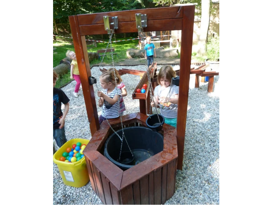Kinder spielen mit einem Wasserspielplatz aus Holz