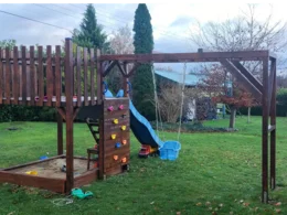 Hölzerner Spielplatz mit Rutsche und Schaukel