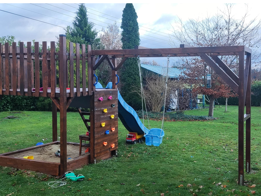 Hölzerner Spielplatz mit Rutsche und Schaukel