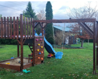 Hölzerner Spielplatz mit Rutsche und Schaukel