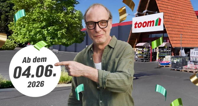 Eine Person steht vor einem Baumarkt und zeigt auf ein Datum.