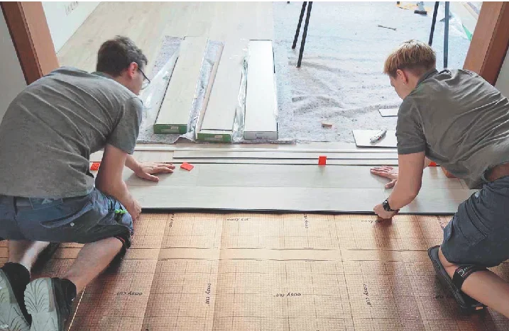 Zwei Personen verlegen Vinylboden.