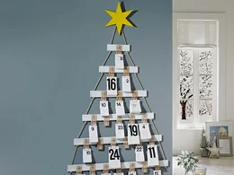 Ein Adventskalender in Form eines Tannenbaums mit weißen nummerierten Umschlägen.