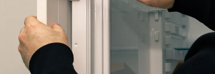 Person befestigt Tür mit Schraubenzieher