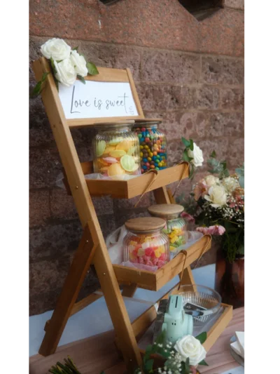 Holzregal mit Süßigkeiten in Gläsern