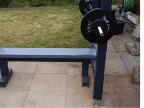 Eine Hantelbank mit einer Langhantel im Garten.