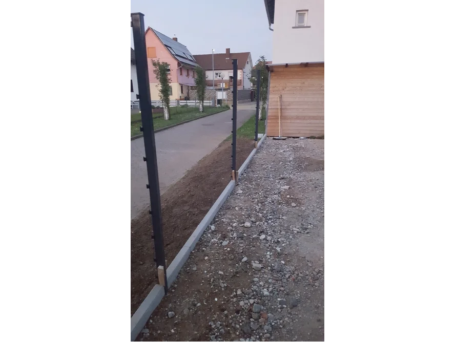 Schwarzer Metallzaun mit Betonfundament
