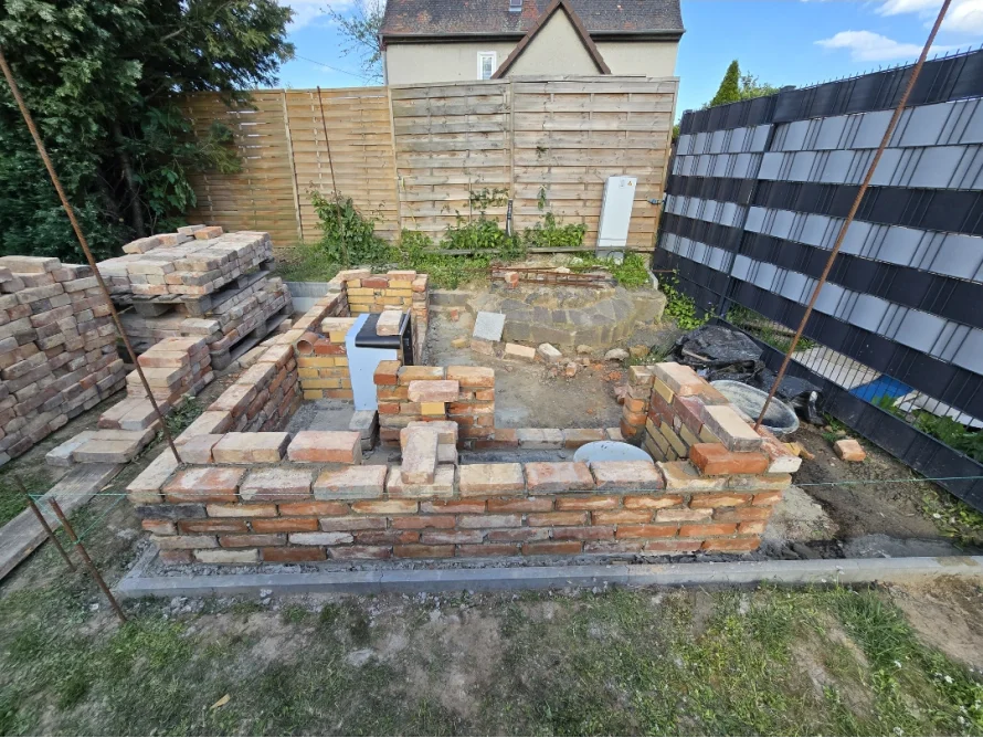 Rohbau einer gemauerten Außenküche im Garten.