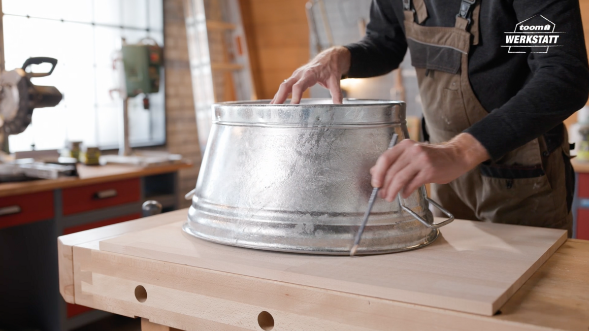 Person zeichnet Kreis auf Holz