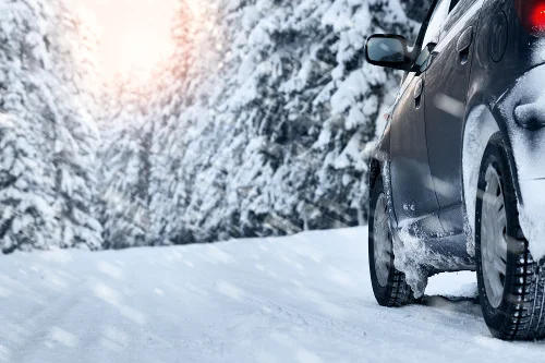 Auto fährt auf verschneiter Straße