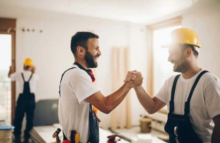 Zwei Bauarbeiter geben sich die Hand