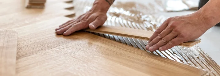 Person verlegt Parkettboden