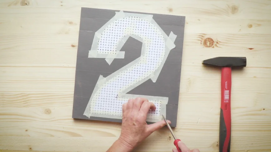 Person schneidet Schablone auf Holzbrett