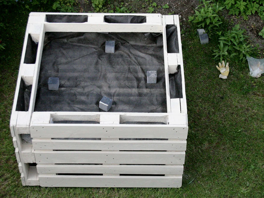 Hochbeet aus weißen Holzpaletten