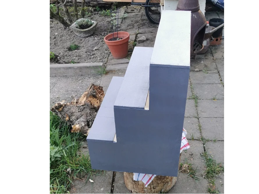 Eine dreistufige Holztreppe in grau.