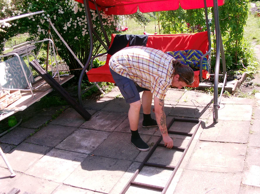 Person baut ein Holzgerüst zusammen