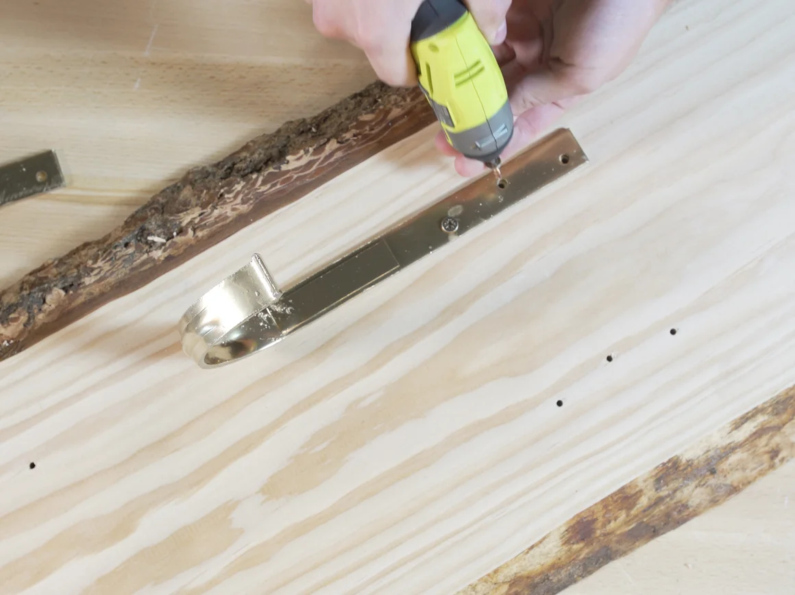 Person befestigt Metall an Holz mit Akkuschrauber