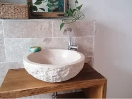 Waschbecken aus Stein auf einem Holztisch