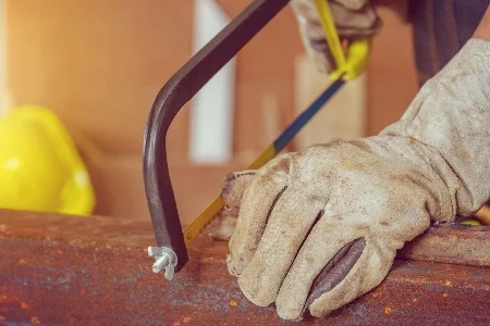 Person sägt Metall mit Bügelsäge