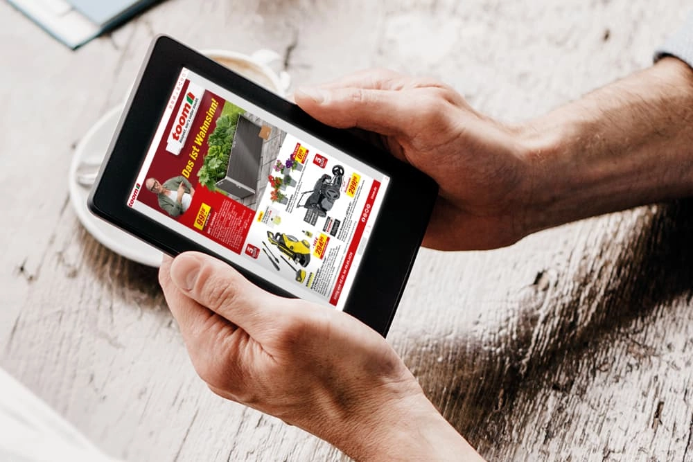 Eine Person blättert in einem digitalen Baumarkt-Prospekt auf einem Tablet.