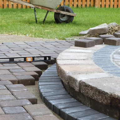 Pflasterarbeiten mit Wasserwaage auf Baustelle