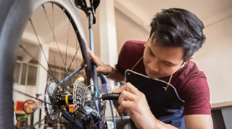 Person repariert Fahrrad mit Werkzeug