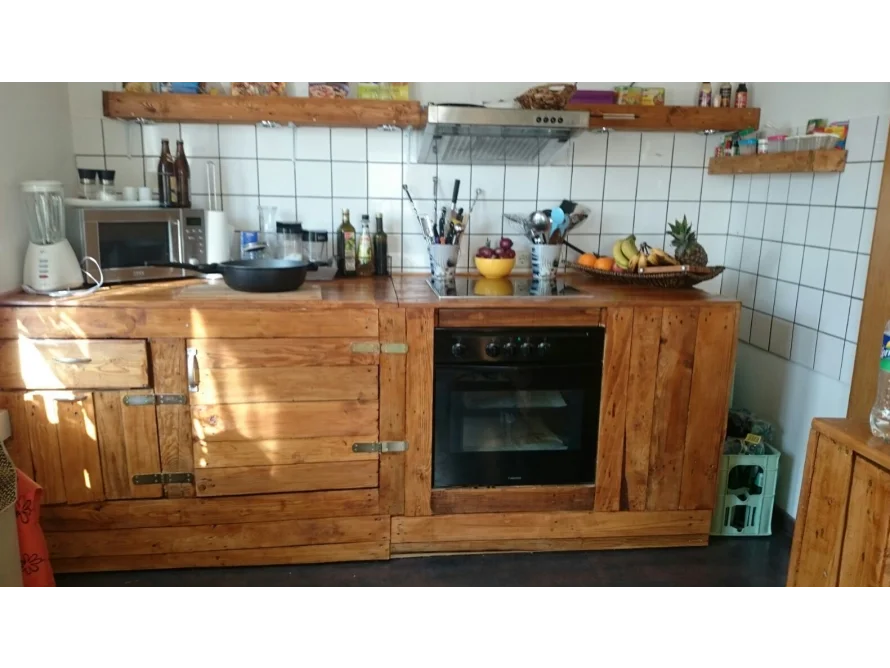 Eine rustikale Küche mit Holzarbeitsplatte und -regalen.