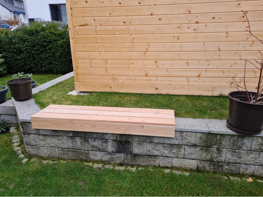 Holzbank vor Gartenhaus