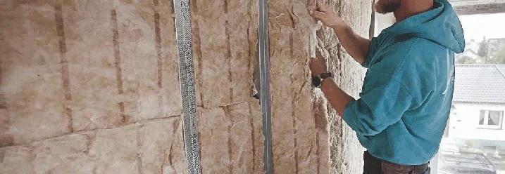 Person bringt Dämmmaterial an