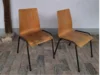 Zwei einfache Stühle mit Holzsitzfläche und schwarzen Metallbeinen