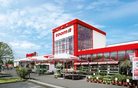 Fassade eines Baumarktes mit Pflanzenverkauf im Vordergrund