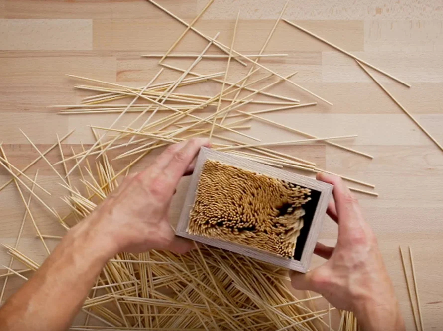 Hände halten einen Messerblock aus Holz und Metall.