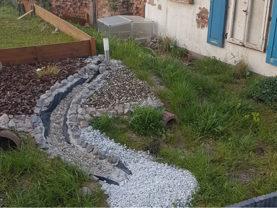 Kiesbett eines Bachlaufs im Garten